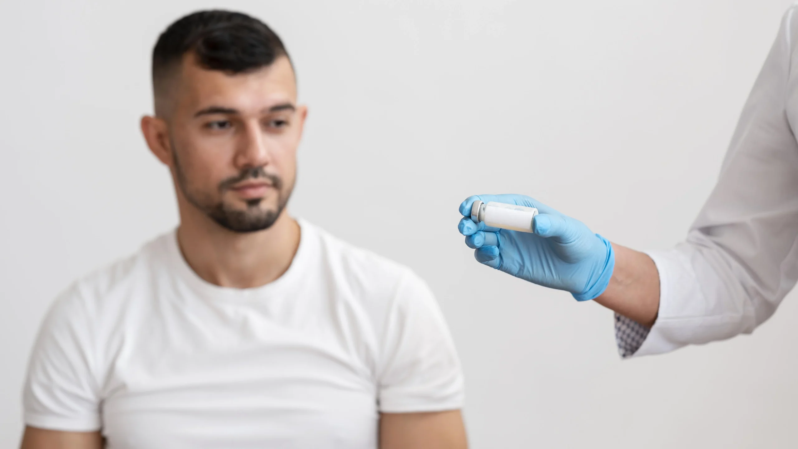 Healthcare provider holding a testosterone vial while consulting with a male patient about testosterone replacement therapy at a Florida TRT clinic