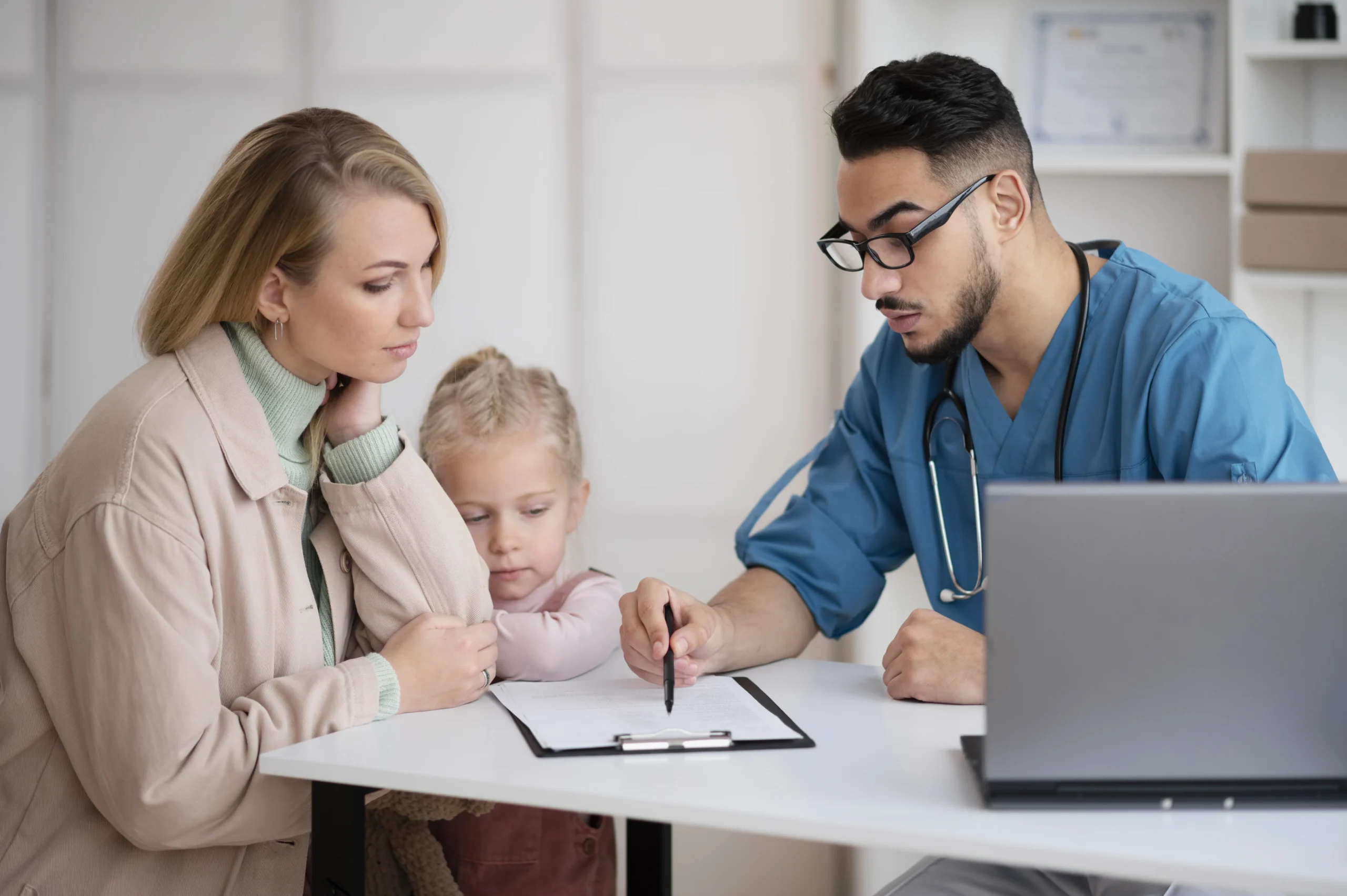 Family doctor in Bradenton discussing a healthcare plan with a mother and child during a family medical consultation